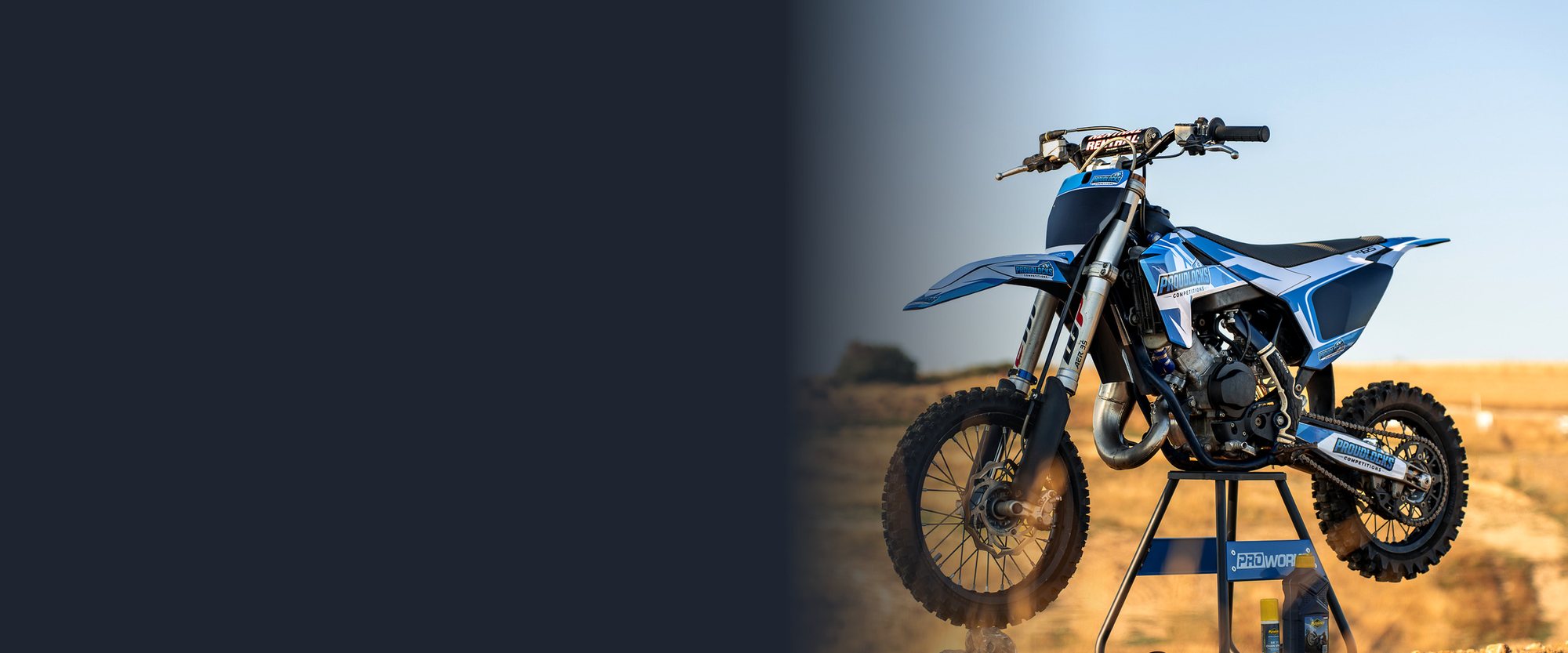 Husqvarna TC 65 motocross bike on a ProWorks stand at a dirt track